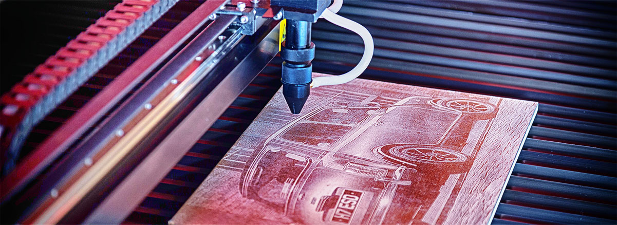 An image of a HPC Laser cutting and engraving a detailed image on a piece of wood