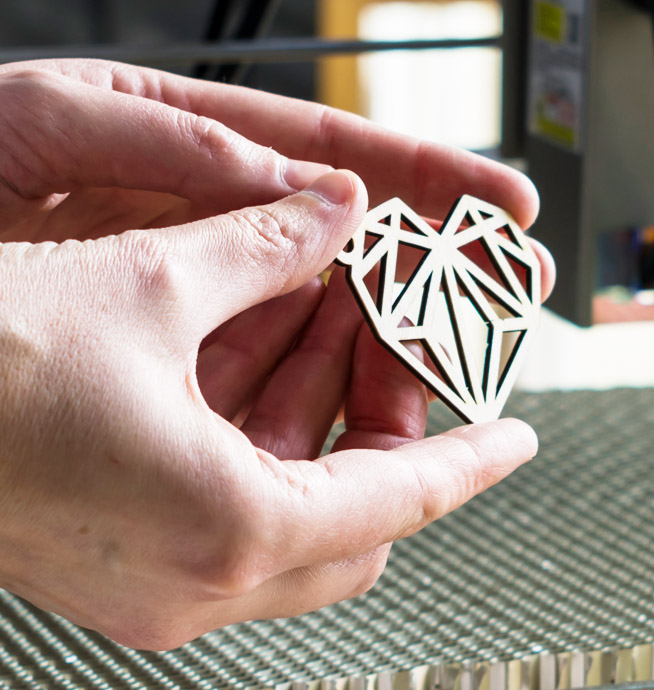 An image of a laser cut geometric heart shape from a piece of wood