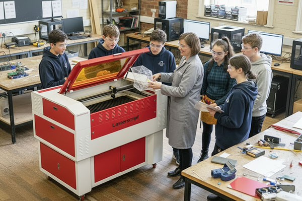 An image of a teacher showing students how to use a HPC CO2 laser cutter