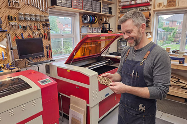 An image of a hobbiest using a CO2 laser cutter