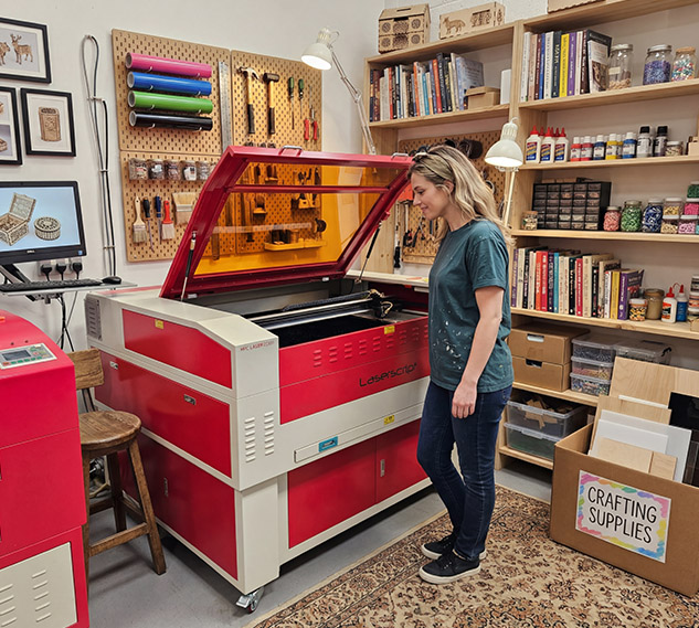 An image of a hobbiest looking at one of the HPC CO2 laser cutters
