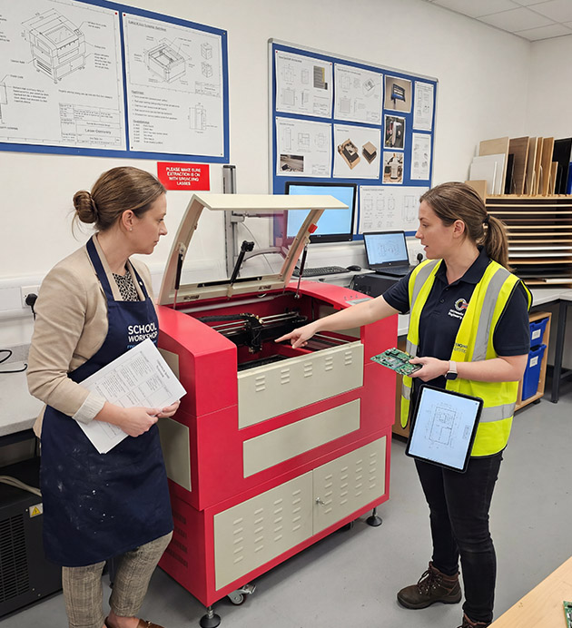 An image of a HPC engineer showing a teacher how to use their CO2 laser cutter in a classroom