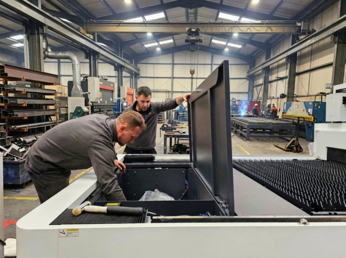 Two men inspecting a Laser Cutting Machine.