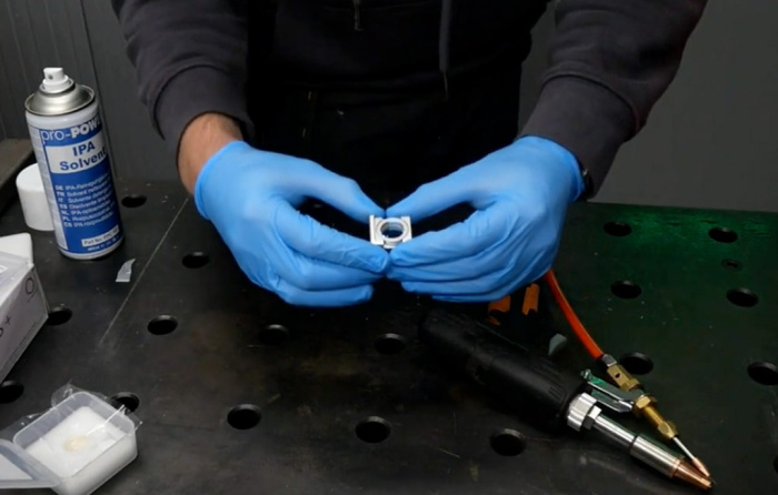 An image of a laser welder focal lens being removed