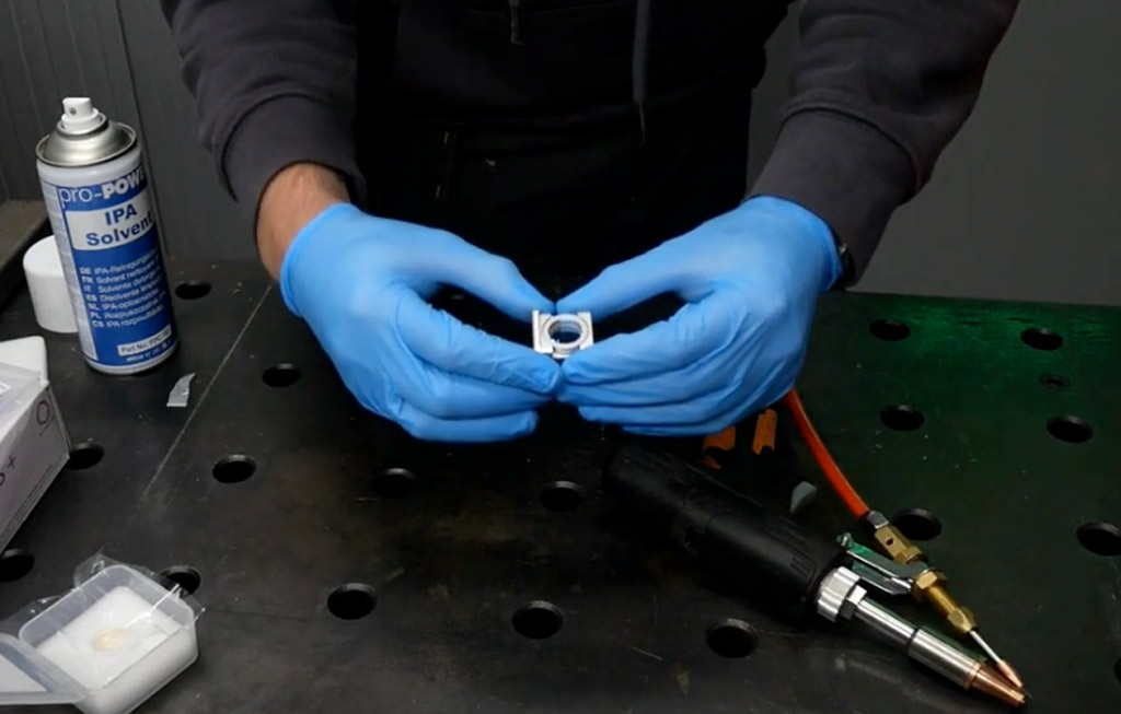 An image of a laser welder focal lens being removed